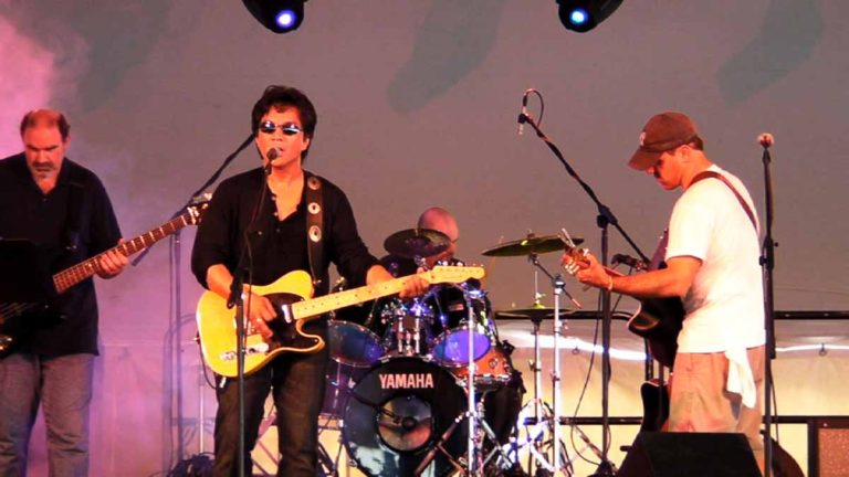 Red Reyne performing on stage with band members